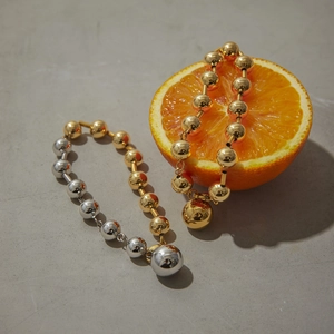 Présentation de bracelets en perles de laiton avec pendentifs et tranches d'oranges
