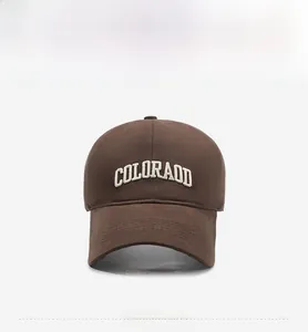 Detailed view of white embroidered Colorado text on a deep brown cotton baseball cap