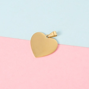 Macro view of polished golden heart-shaped pendant with metal ring on dual-tone background