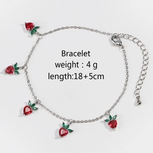Close-up of strawberry pendant bracelet with red cubic zirconia on silver chain