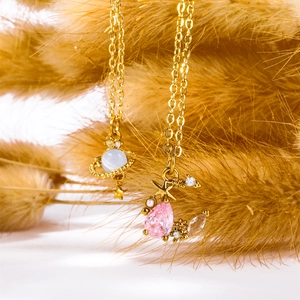 Detail of Saturn planet and crescent moon pendants with pink and blue gemstones