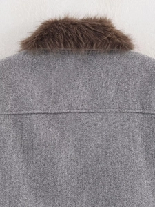 Close-up of gray wool fabric texture and thick brown faux fur collar on a winter jacket