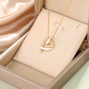 Elegant gold heart necklace with white enamel and sparkling diamonds on silk display
