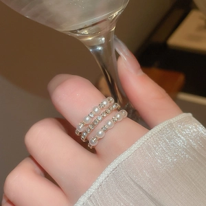 Detailed view of elegant multi-layer gold ring with pearls and sparkling diamonds
