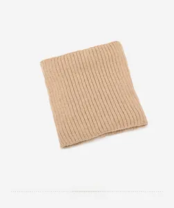 Dettaglio dello scaldacollo in maglia beige con trama a coste verticali elastiche