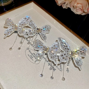 Detail shot of sparkling silver butterfly hair clip with diamond fringe and tassels