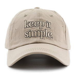 Dettaglio del cappello da baseball in cotone con ricamo nero 'keep it simple' su beige