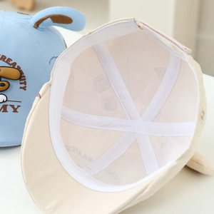 Detail view of baby hat showing breathable mesh lining and cute cartoon dog embroidery