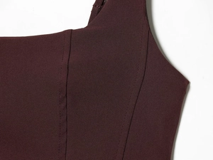 Detailed view of burgundy stretch fabric and stitching on sexy fishtail evening dress