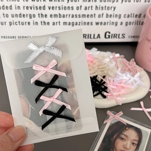 Close-up of mini DIY ribbon bows in silver, pink, and black for creative handcrafting