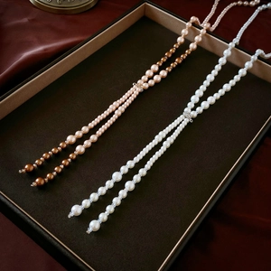 Elegant layered long pearl necklace with crystal accents in cream and champagne colors