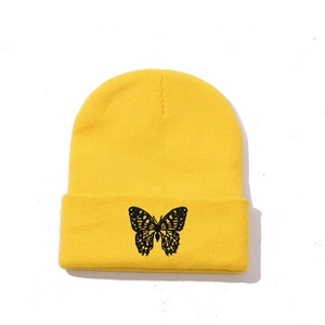 Close-up of black butterfly embroidery on a vibrant yellow knitted beanie hat