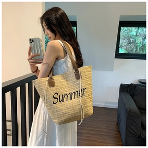 Detail of hand-woven straw tote bag with Summer embroidery and durable PU shoulder strap