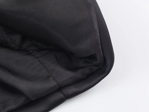 Detailed close-up showing the black herringbone wool texture and precise stitching detail