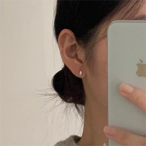 Minimalist 925 sterling silver bean-shaped stud earrings worn as a stylish daily accessory