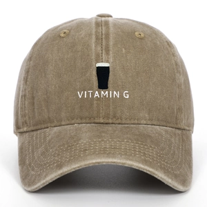 Makrodetail der Vitamin G-Stickerei und des gewaschenen braunen Baumwollstoffs der Kappe