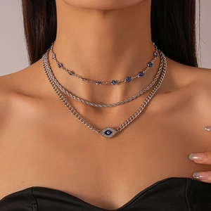 Three-layer silver necklace set featuring blue evil eye charms and diamond accents
