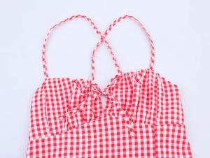 Detail eines roten Gingham-Midikleids mit Schleife vorne und feiner Webstruktur
