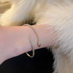 Opvallende slangvormige open armband met diamant-inleg en metalen schubtextuur