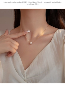 Detail of S925 sterling silver gold necklace with white pearl on model's neck