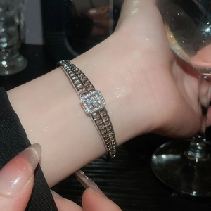 Gros plan d'un bracelet jonc argenté avec zircon carré sur le poignet d'un mannequin