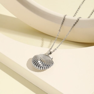 Macro view of shell-shaped locket necklace with fine vertical stripe texture detail