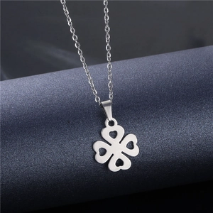 Elegant silver stainless steel four-leaf clover necklace with heart cutouts on a blue roll