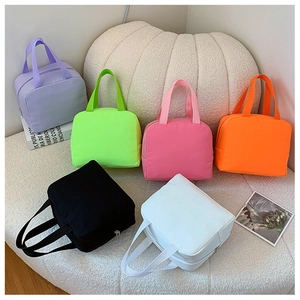Detailed view of six colorful canvas lunch bags with zipper closure and top handles