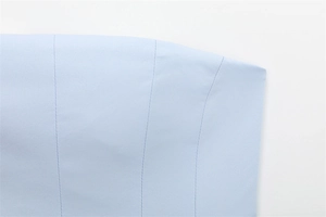 Detailed close-up of light blue fabric texture with precise parallel stitching craftsmanship