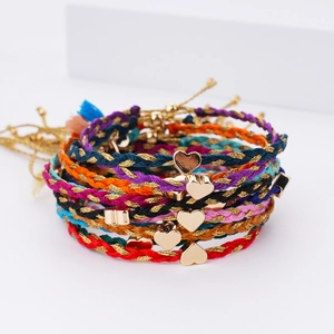 Handmade woven friendship bracelets with gold heart pendants in assorted vibrant colors