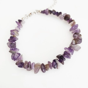 Macro detail of natural amethyst chips with a silver lobster clasp and extension chain