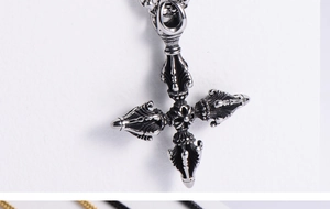 Macro shot of silver retro religious cross pendant with black enamel details