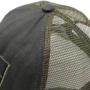 Macro detail of dark olive green mesh trucker hat showing top button and stitching