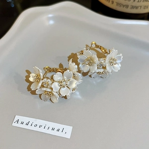 Gros plan de boucles d'oreilles fleur perle avec pistils dorés et accents de strass