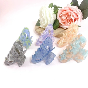 Set of six marble pattern acrylic hair claws in assorted colors on pink background