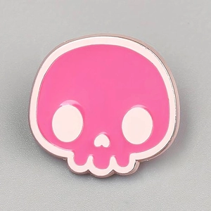 Close-up of pink skull enamel brooch with rose gold metal edges for Halloween