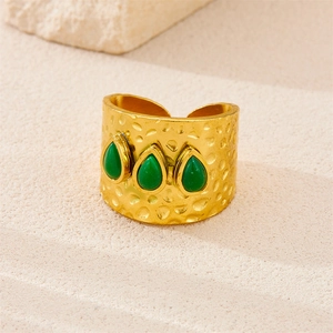 Macro shot of 18k gold plated hammered texture ring featuring three green pear-shaped stones
