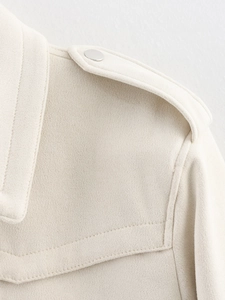 Close-up of beige faux suede jacket showing shoulder epaulets and stitching details