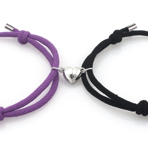 Détail du fermoir magnétique en cœur reliant les bracelets tressés violet et noir