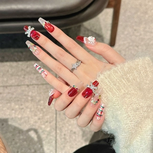 Handmade red Christmas press-on nails with 3D Santa and bear decor on model hands
