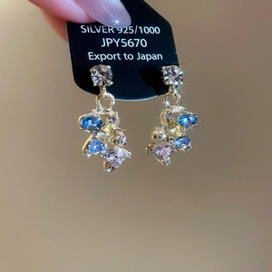Detail of gold horse earrings with colorful zircon stones and 925 silver needles