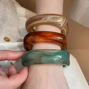 Irregular acrylic resin bangles with marble texture in white, amber, and teal green colors