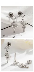 Detailed view of silver bow and candy cane pendant earring with micro zircon inlay