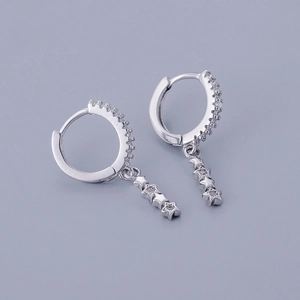 Macro detail of S925 silver hoop earrings with triple star pendants and zircon stones