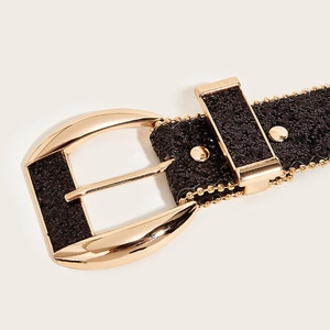 Detail of a sparkling black rhinestone belt with a polished gold arc metal buckle