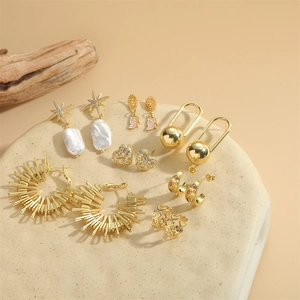 Elegant gold jewelry set with heart studs, star pearl earrings, and butterfly charms