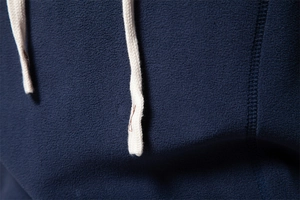 Macro shot of navy fleece fabric texture and cream white braided drawstring details