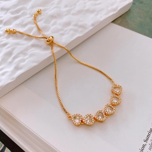 Détail du bracelet cœur doré ajustable avec pierres en zircon et fermoir coulissant