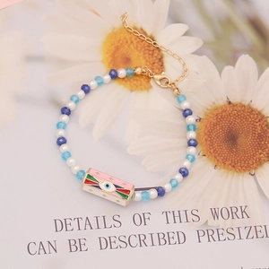 Bohemian style bracelet with blue faceted beads, white pearls and colorful enamel evil eye