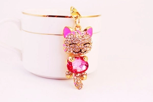 Close-up of a sparkling crystal lucky cat keychain with a pink gemstone and gold finish